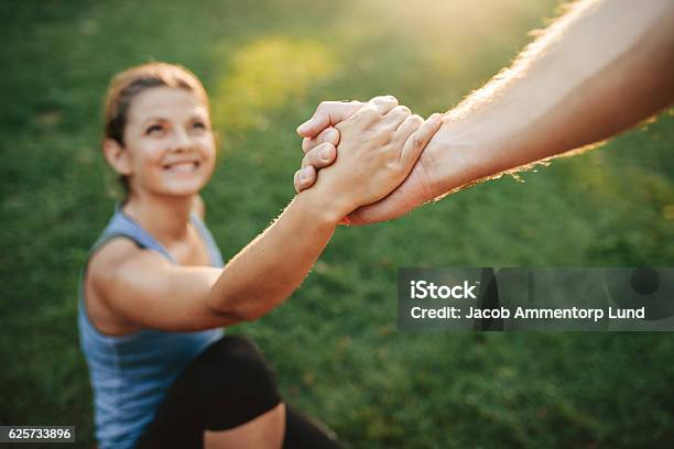 Man Helping Woman To Stand Up Stock Photo - Download Image Now - A Helping Hand, Support, Assistance