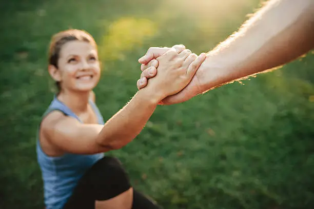 Photo of Man helping woman to stand up