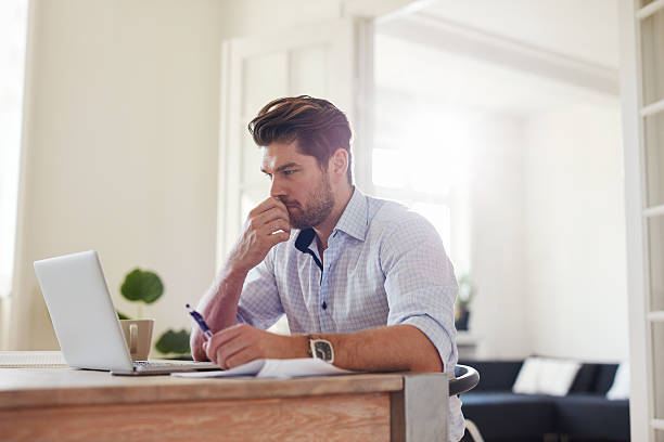 istock Pensive young man working on laptop at home 625734934