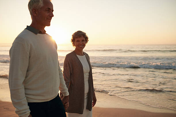 istock Senior woman with her husband strolling on the beach 625736008