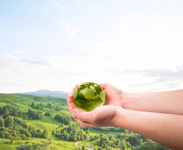 istock Woman holding a green Planet Earth globe in her hands 625739572