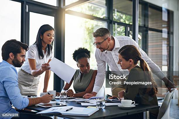 Exchanging Ideas In The Boardroom Stock Photo - Download Image Now - Teamwork, Multiracial Group, Business
