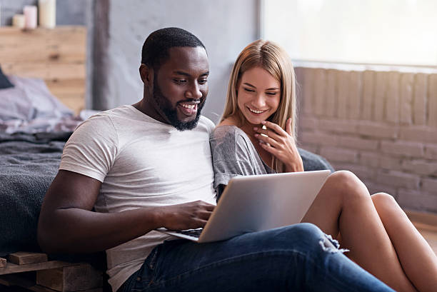 istock Happy couple using laptop in bedroom together 625751788
