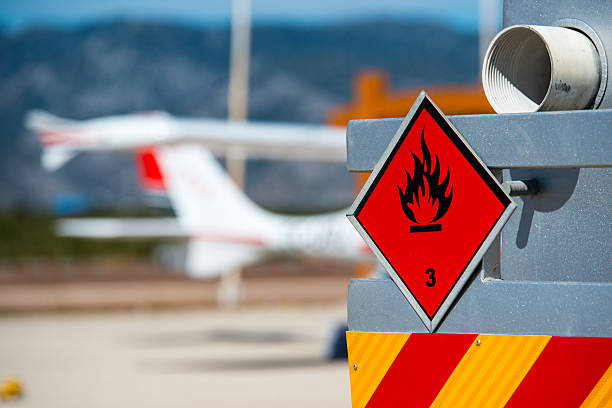 Chemical hazard, flammable liquids. Rear view of service and refueling truck on an airport with an aircraft in the blurry background. Chemical hazard, flammable liquids. flammable photos stock pictures, royalty-free photos & images