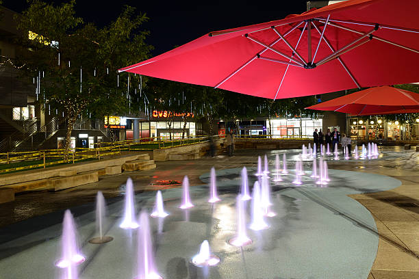 Phoenix, USA - December 24, 2015. Night view of fountains at CityScape with people chatting in background in downtown Phoenix. Phoenix is the state capital of Arizona. It is the largest and most populous city in the state and attracts people for its warm weather and closeness to such natural wonders as Grand Canyon.
