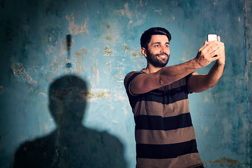 Young man taking a selfie; ample copyspace.