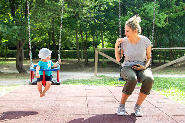 baby mother swing playground looking each other