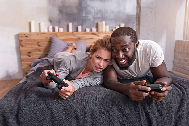 istock Overjoyed couple enjoying video games in bed 625757668