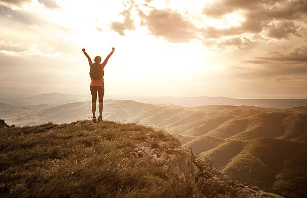 femme saluant le soleil sur le sommet de la colline - mountain women victory winning photos et images de collection