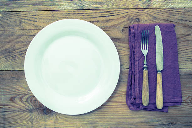 istock White plate with cutlery on wooden background 625758504