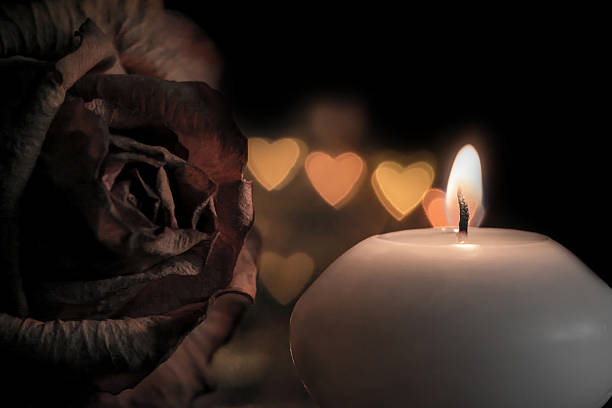 istock Candle with rose flower on bokeh hearts background. 625759804