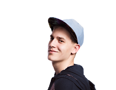 Teenage boy in blue sweater and cap. Young man smiling. Studio shot on white background, isolated.
