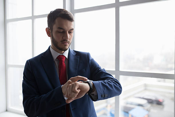 istock What time is it now. Businessman looking at watch. 625769858