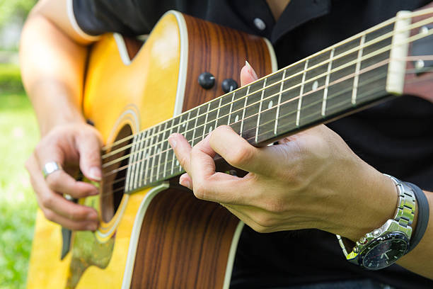 istock playing guitar in the park 625773472