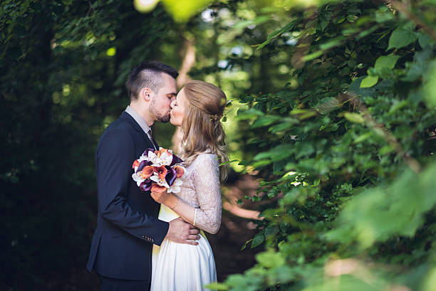 Beautiful bride and groom kissing outdoors