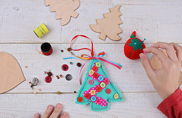 Child making felt Christmas Tree decoration ornament close up