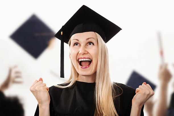 帽子とガウンを着て若い幸せな大学卒業生 - cheering arms raised women university ストックフォトと画像