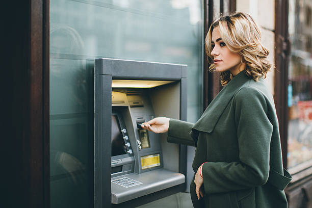 mujer joven con cajero automático - banking bill women human hand fotografías e imágenes de stock