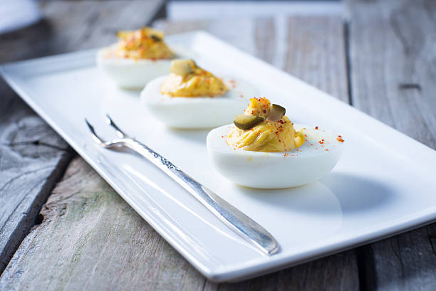Spicy deviled eggs appetizer on clean plate stock photo