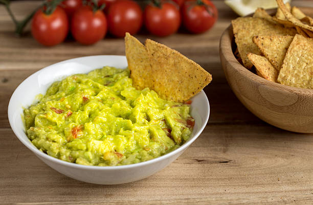 istock Guacamole in white bowl on wooden desk. 625792500