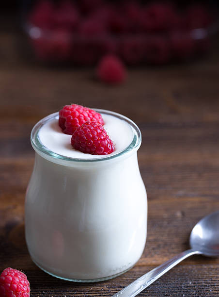 istock White yogurt with raspberries in glass bowl. 625792540