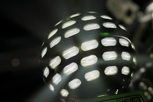 Bright coloured moving white disco lightball shot in darkened nightclub