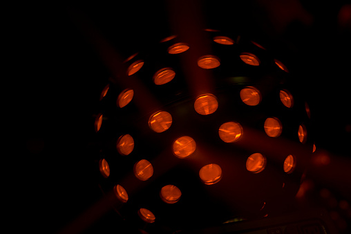 Bright coloured moving red disco lightball shot in darkened nightclub