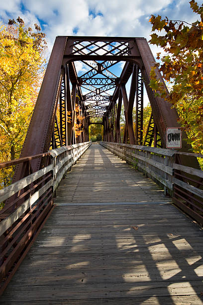 Iron bridge carries the Farmington River Trail in Canton, Connec Bridge over the river carries the Farmington River Trail for hiking and biking in the Collinsville section of Canton, Connecticut. ironbridge shropshire stock pictures, royalty-free photos & images