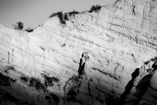 cliff with eroded natural statue in black and white