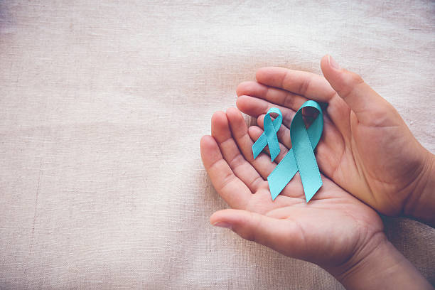 Hands holding Teal Ribbons, copy space toning background, Ovaria Hands holding Teal Ribbons, copy space toning background, Ovarian Cancer, cervical Cancer, Kidney Cancer awareness cervical cancer photos stock pictures, royalty-free photos & images