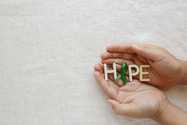 hope with lime green ribbon on hands ,lyme disease - lyme disease imagens e fotografias de stock