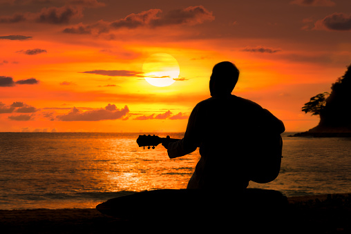 A song writer inspiring with stunning sunset horizon over andaman sea.