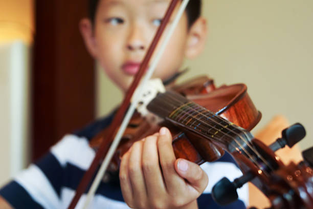istock boy plays voilin 625811686