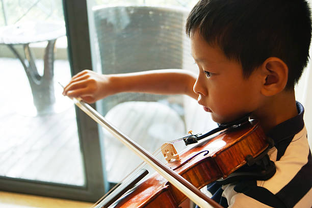 istock boy plays voilin 625811722