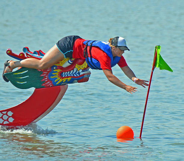 Denver, CO, USA - July 31, 2016: Over 110,000 people attended the 16th Annual Colorado Dragon Boat Festival and enjoyed the exciting dragon boat races as well as all the numerous demonstrations, vendors and delicious foods. Unidentified team competing in the exciting boat races. One of the competitors reaching for the flag at the finish line. 