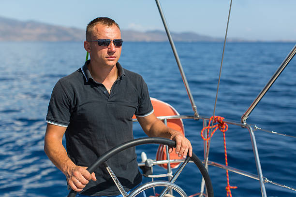 istock Man skipper at the helm sail boat 625842200