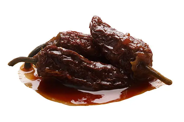 Chipotles en Adobo, a whole smoke-dried overripe Jalapeno peppers in seasoning. Clipping path