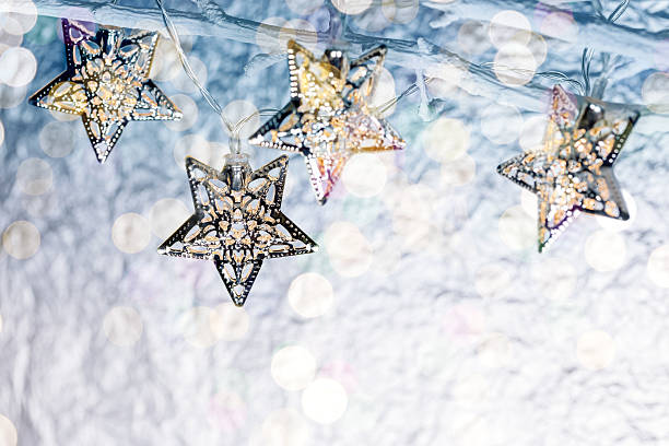 istock christmas star-shaped holiday lights hanging on bare branches 625854562