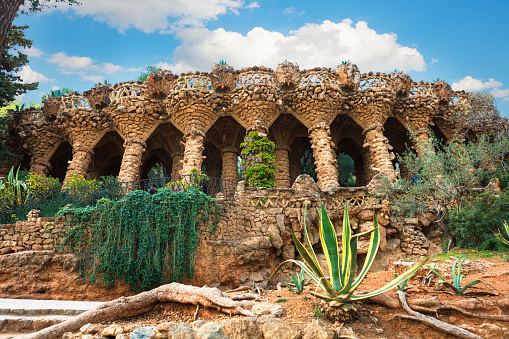 columns among the trees made of stone in Park Guell designed by Antoni Gaudi in Barcelona, Spain, modernism style