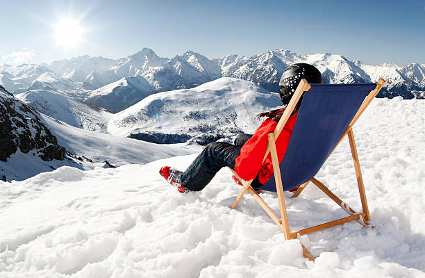 女性の冬には山のサンラウンジチェア  - apres ski lifestyles people blue ストックフォトと画像