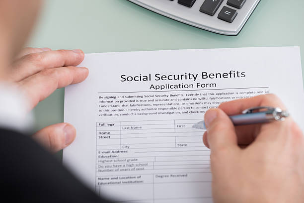 Person Hand Filling Social Security Benefits Form Close-up Of Person Hand Filling Social Security Benefits Form social security stock pictures, royalty-free photos & images