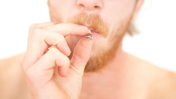 istock closeup of young man smoking a joint 625879828