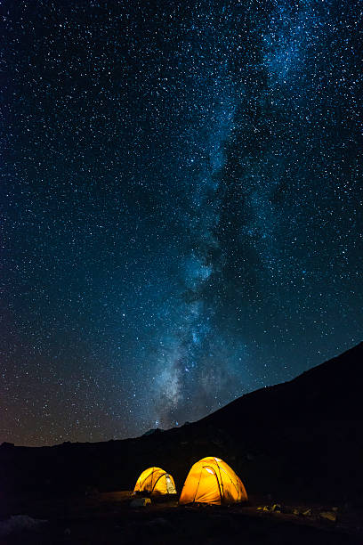 milky way stars shining over illuminated mountain tents himalayas nepal - khumbu imagens e fotografias de stock