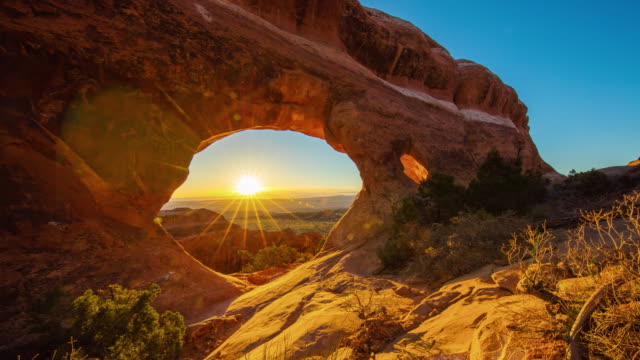 T/L 4K Sunrise over a sandstone arch formations