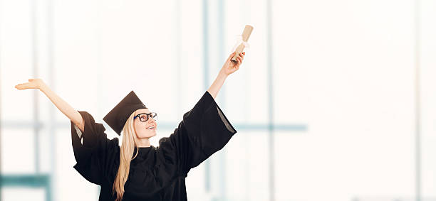 istock graduation - happy student in gown with diploma 625889600