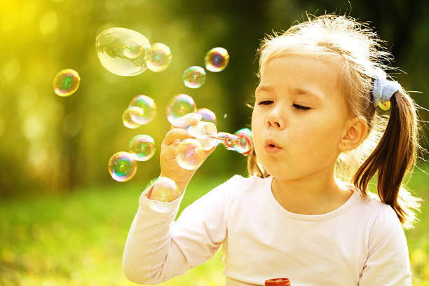 istock Little girl is blowing a soap bubbles 625889602
