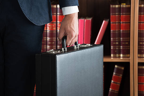 istock Lawyer Carrying Briefcase Against Bookshelf 625890414