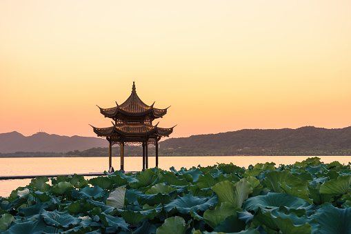 chinese ancient pavilion with sunset at the west lake in hangzhou