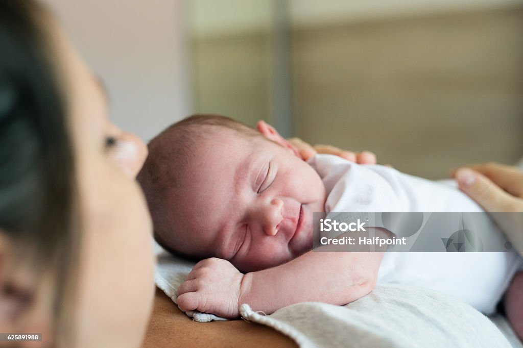 Mère méconnaissable avec un nouveau-né couché dans son lit - Photo de Nouveau-né libre de droits