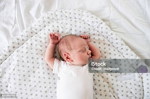 Newborn Baby Boy Lying On Bed Sleeping Close Up Stock Photo - Download Image Now - Baby - Human Age, Newborn, Sleeping